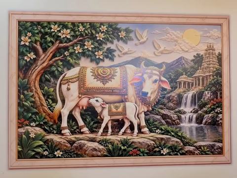 Kamadhenu and calf by a waterfall, printed as a framed scene on a living room wall